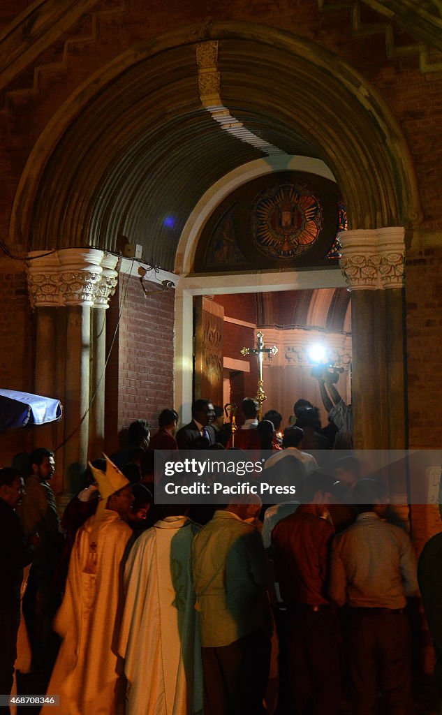 Pakistani Christian worshipers pray and hold candles during...