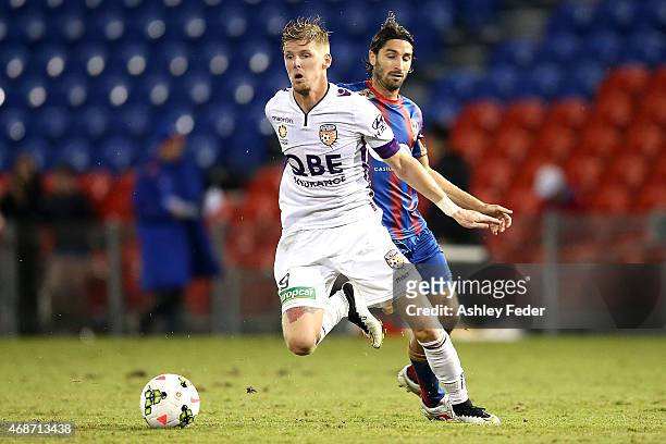 Andrew Keogh of Perth Glory is tackled by Zenon Caravella of the Jets during the round 24 A-League match between the Newcastle Jets and Perth Glory...