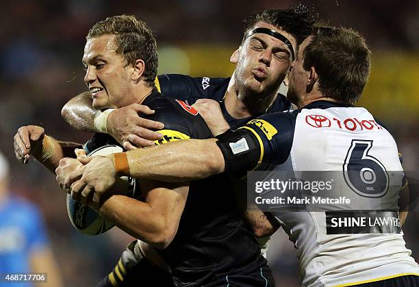 Matt Moylan of the Panthers is tackled by Ethan Lowe and Michael Morgan of the Cowboys during the round five NRL match between the Penrith Panthers...