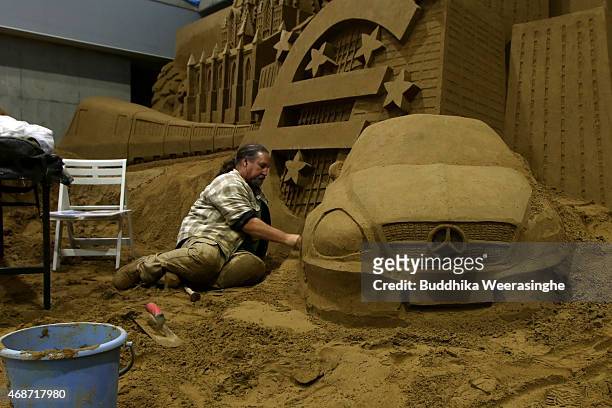 Sand artist Brad Goll of the U.S.A. Works on his sand sculpture named 'Modern Germany' ahead of 'Germany and Once Upon a Time' exhibition at the Sand...