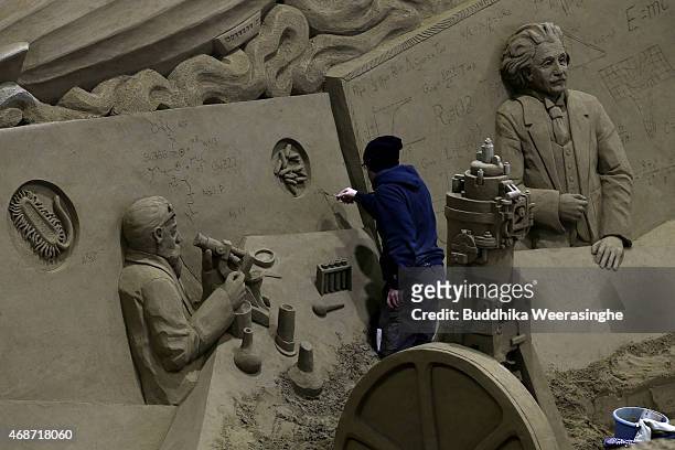 Sand artist Gyu Deveau of Canada works on his sand sculpture named 'Science and Technology in Germany' ahead of 'Germany and Once Upon a Time'...