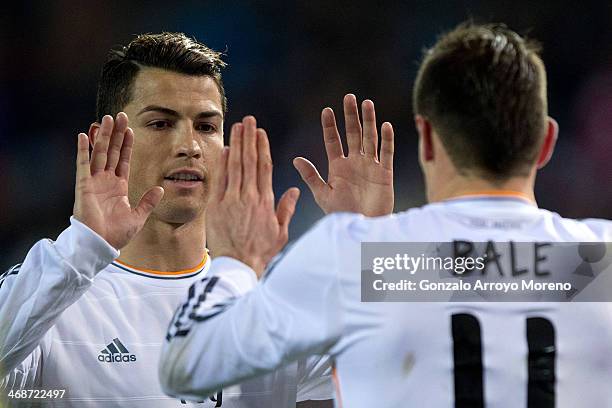 Cristiano Ronaldo of Real Madrid CF clashes hands with his teammate Gareth Bale after a penalty over Bale during the Copa del Rey semi-final second...