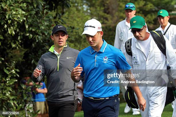 Rory McIlroy of Northern Ireland walks with amateur Bradley Neil of Scotland during a practice round prior to the start of the 2015 Masters...