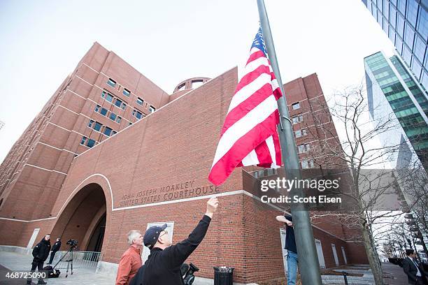 An American flag is raised outside of John Joseph Moakley United States Courthouse before the beginning of closing arguments in the Boston Marathon...