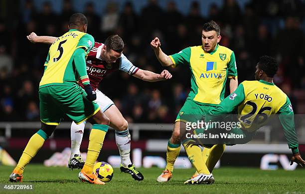 Kevin Nolan of West Ham United is challenged by Sébastien Bassong , Robert Snodgrass and Joseph Yobo of Norwich City during the Barclays Premier...
