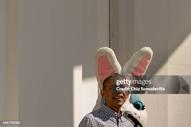 President Barack Obama delivers opening remarks from the Truman Balcony as a person dressed as the Easter Bunny stands behind him during the White...