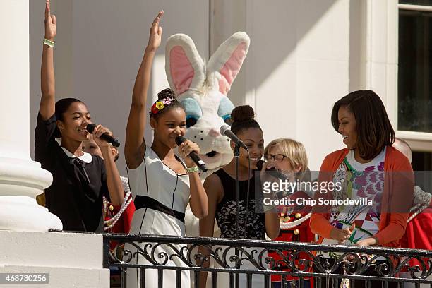 The singing group iD4Girls perform the national anthem as first lady Michelle Obama looks on during the White House Easter Egg Roll on the South Lawn...