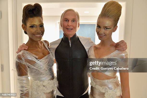 Fredric S. Brandt poses with models at the viewing of his Art Collection cocktail party on December 4, 2012 in Coconut Grove, Florida.