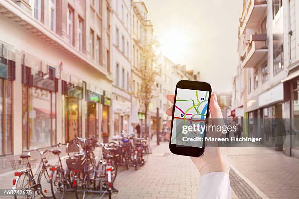 hand holding smart phone with map app in city - nrw karte stock-fotos und bilder