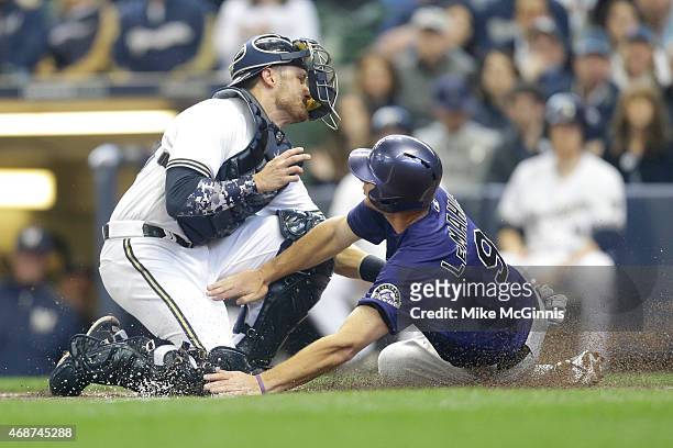 Jonathan Lucroy of the Milwaukee Brewers makes the tag on D.J. LaMahieu of the Colorado Rockies as he slides into home plate during the second inning...