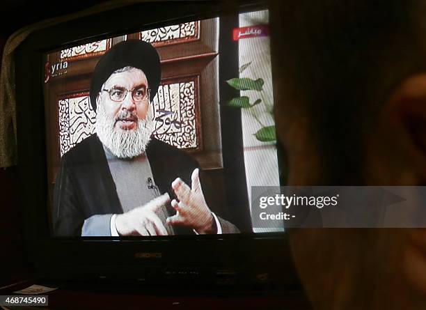 Syrian watches an interview of Hassan Nasrallah, the head of Lebanon's militant Shiite Muslim movement Hezbollah, screened on Syria's official...