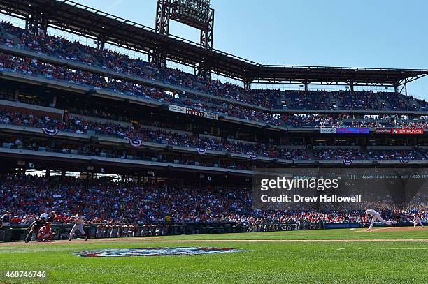Starting pitcher Cole Hamels of the Philadelphia Phillies delivers the first pitch to Mookie Betts of the Boston Red Sox during Opening Day at...