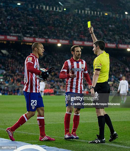 Referee Undiano Mallenco shows the yellow card to Joao Miranda as teammate Juan Francisco Torres alias Juanfran looks on during the Copa del Rey...