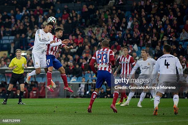 Raphael Varane of Real Madrid CF wins the header after Diego Ribas of Atletico de Madrid during the Copa del Rey semi-final second leg match between...