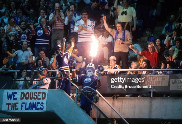 An Edmonton Oilers fan holds a megaphone and shoots flames out of his hat, which is a small Stanley Cup replica, during the 1985 Stanley Cup Finals...