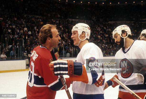 Guy Lafleur of the Montreal Canadiens shakes hands with Mike Bossy and John Tonelli of the New York Islanders after Game 6 of the 1984 Conference...