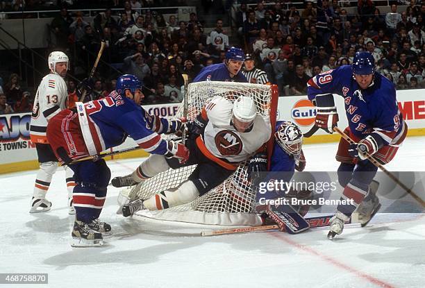 Mathieu Schneider of the New York Rangers checks Mariusz Czerkawski of the New York Islanders into the net as goalie Mike Richter and Wayne Gretzky...