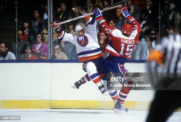Dave Langevin of the New York Islanders and Alan Haworth of the Washington Captials collide during their game circa 1985 at the Nassau Coliseum in...