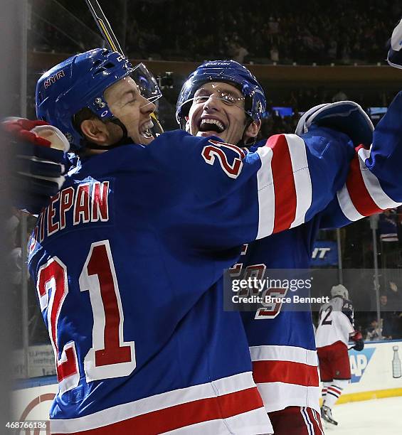 Derek Stepan of the New York Rangers celebrates his game winning overtime goal against the Columbus Blue Jackets along with Dan Girardi at Madison...