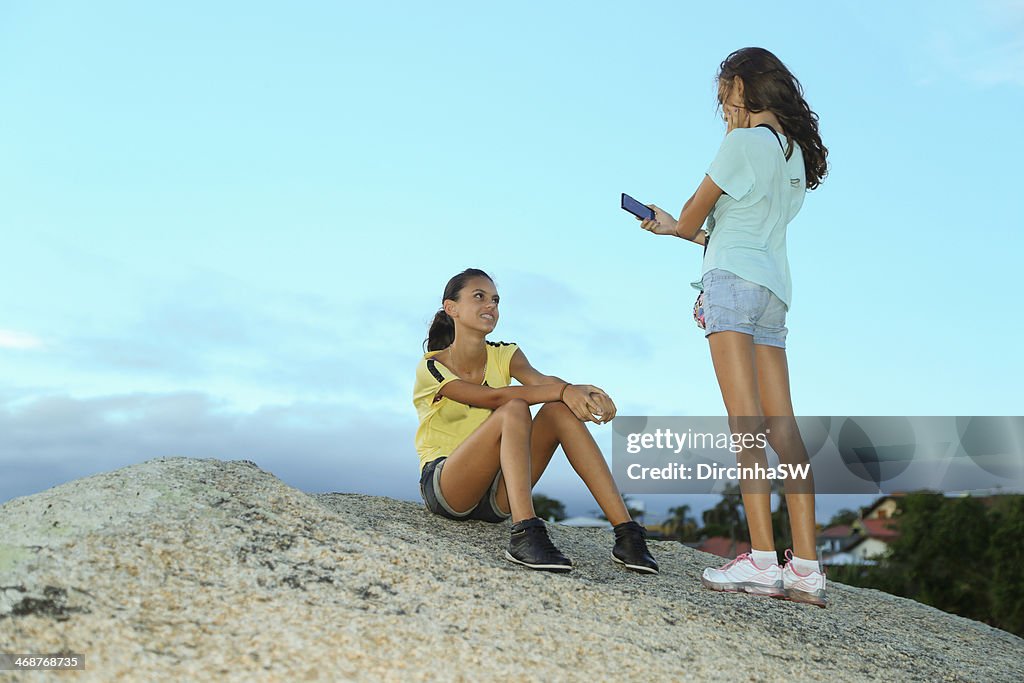 Girls taking photos on stones.