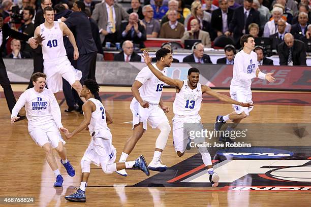 Quinn Cook, Jahlil Okafor and Matt Jones of the Duke Blue Devils celebrate with teammates after defeating the Wisconsin Badgers during the NCAA Men's...