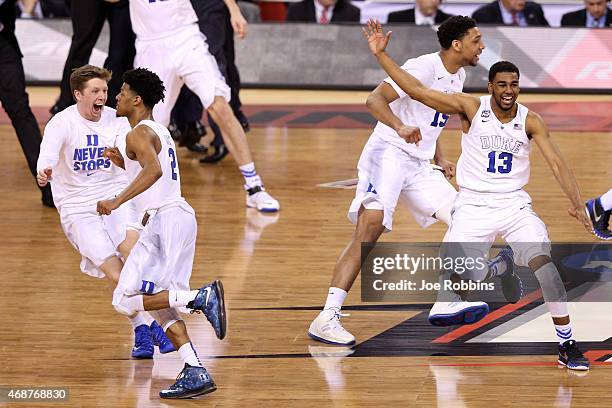 Quinn Cook, Matt Jones and Jahlil Okafor of the Duke Blue Devils celebrate with teammates after defeating the Wisconsin Badgers during the NCAA Men's...