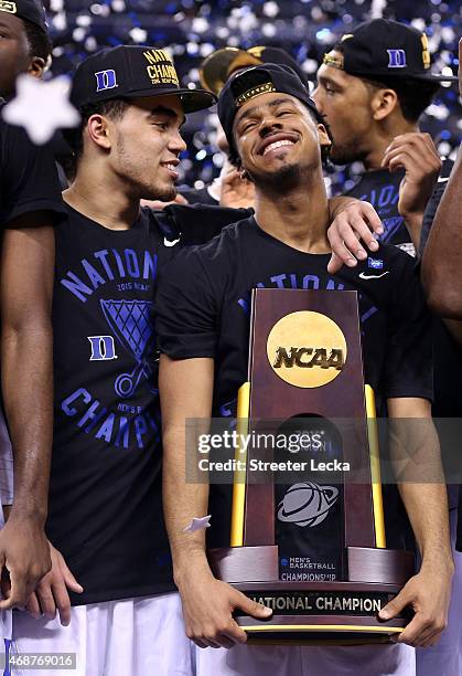 Tyus Jones and Quinn Cook of the Duke Blue Devils celebrate with the championship trophy after defeating the Wisconsin Badgers during the NCAA Men's...