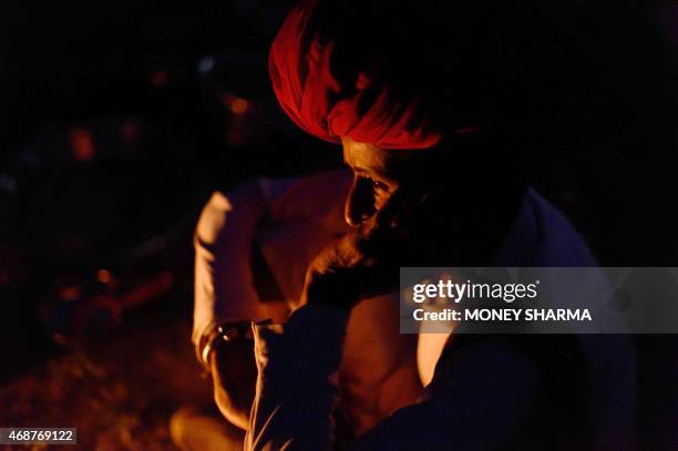 In this photograph taken on March 24 Indian nomadic shepherd Dhana Ram looks on as he waits for dinner to be cooked at his camp at Sikri in Faridabad...