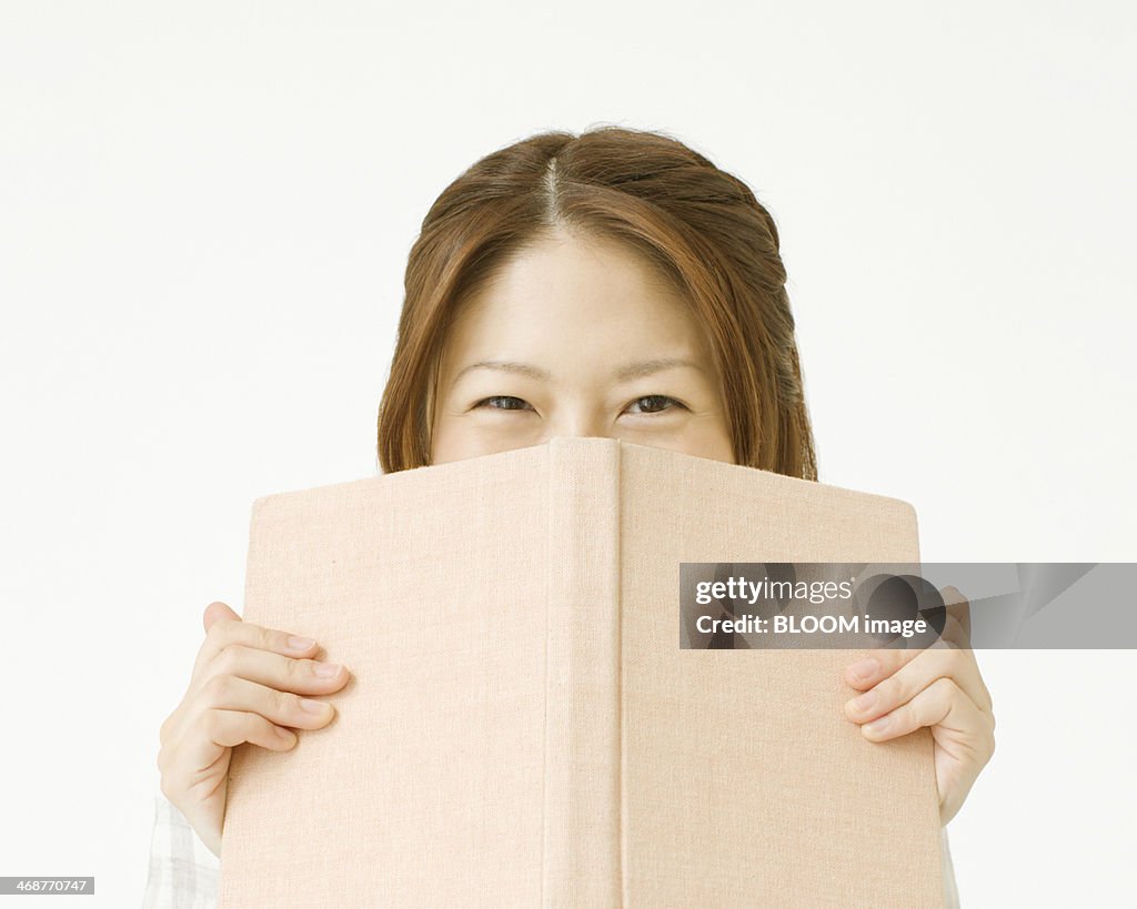 Woman Holding Book In Front Of Face