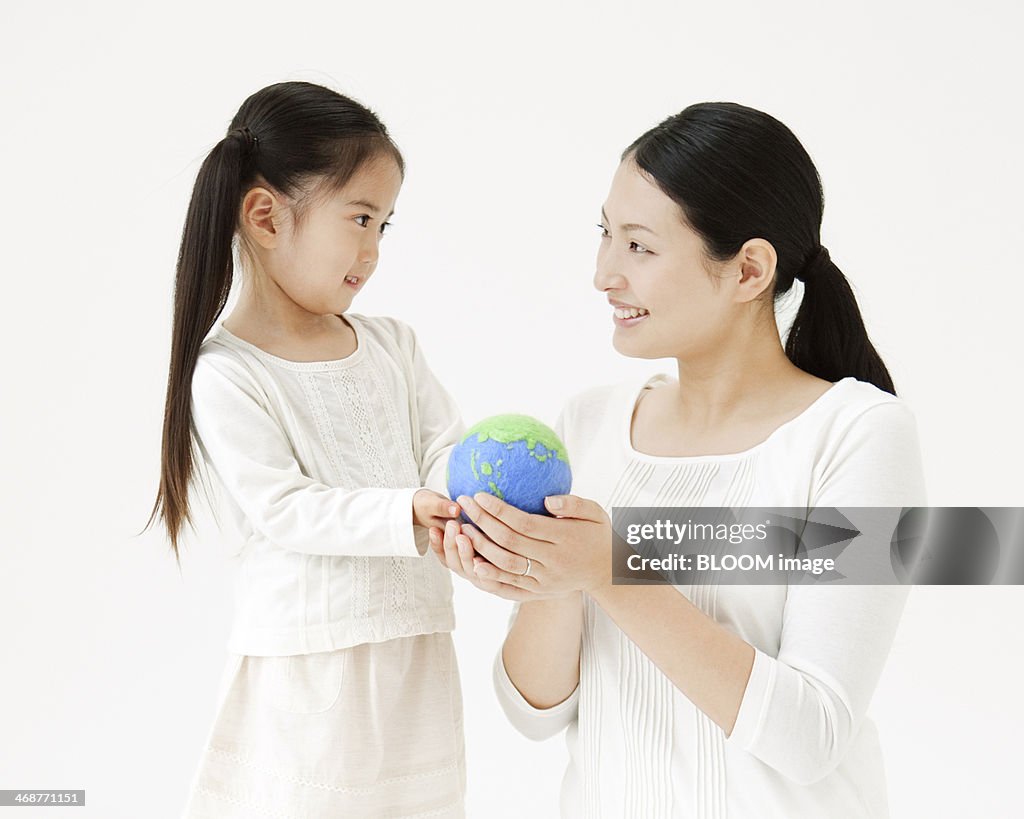 Mother And Daughter Holding A Globe