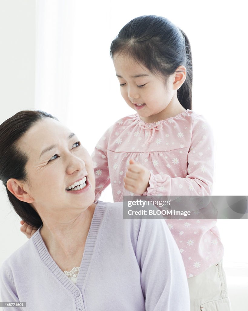 Granddaughter Tapping On Grandmother's Shoulder