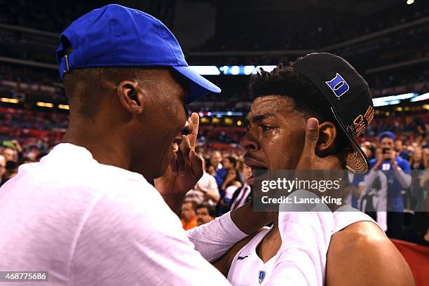 Quinn Cook of the Duke Blue Devils talks to former Duke basketball player Nolan Smith following their win against the Wisconsin Badgers during the...
