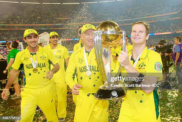 David Warner sparys champagne on Steven Smith of Australia as he holds the World Cup trophy aloft as Australia celebrate winning the 2015 ICC Cricket...