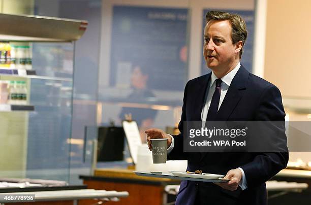 British Prime Minister David Cameron carries a tray with breakfast during a visit to financial firm Scottish Widows on April 7, 2015 in Edinburgh,...