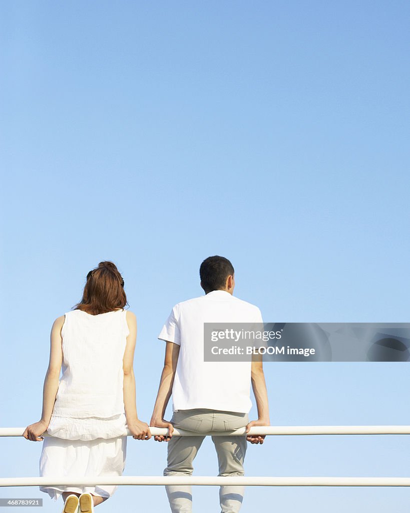 Young Couple Sitting On Railing