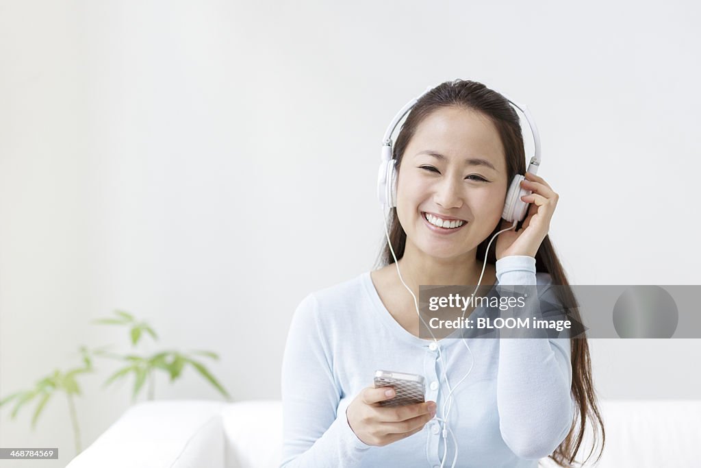 Young woman listening to mp3 player