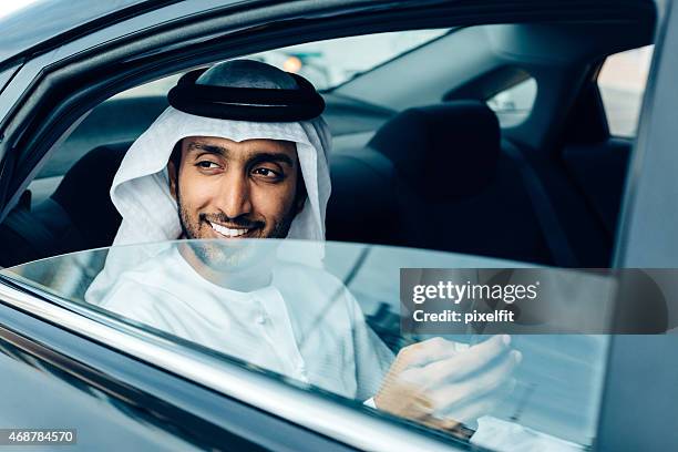 an emirati businessman on his phone in a car - arab businessman stock pictures, royalty-free photos & images