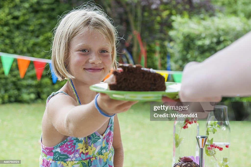 Girl receiving piece of cake on a birthday party