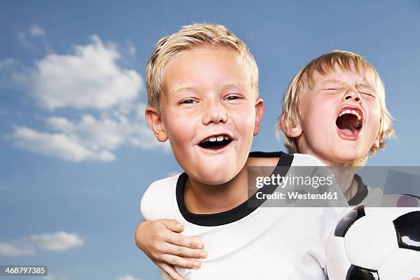 germany, cologne, two boys playing football, wearing football shirts - fußball 2 jungs stock-fotos und bilder