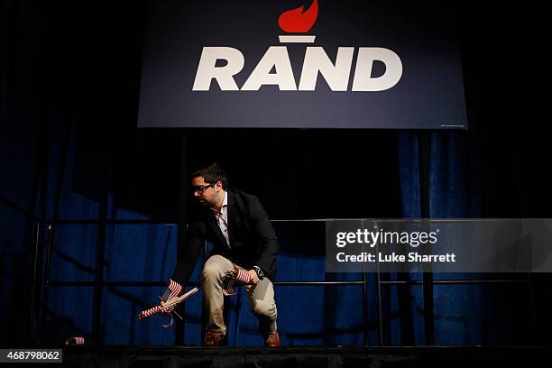 Campaign staffer Dave Ramirez distributes american flags on stage Sen. Rand Paul delivers remarks announcing his candidacy for the Republican...