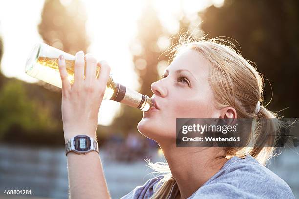 young woman drinking beer of a bottle - cologne bottle stock pictures, royalty-free photos & images