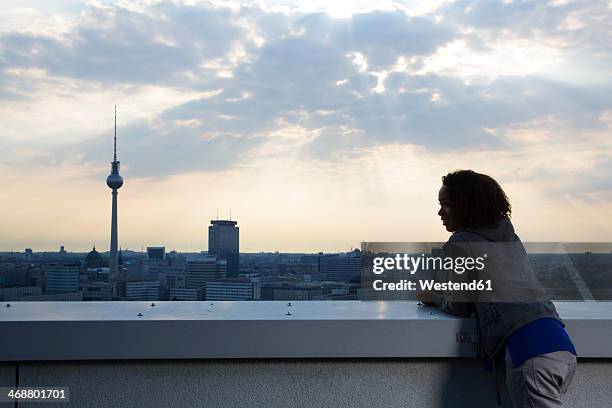 germany, berlin, young woman on rooftop terrace, looking at view - tour de la radio de berlin photos et images de collection