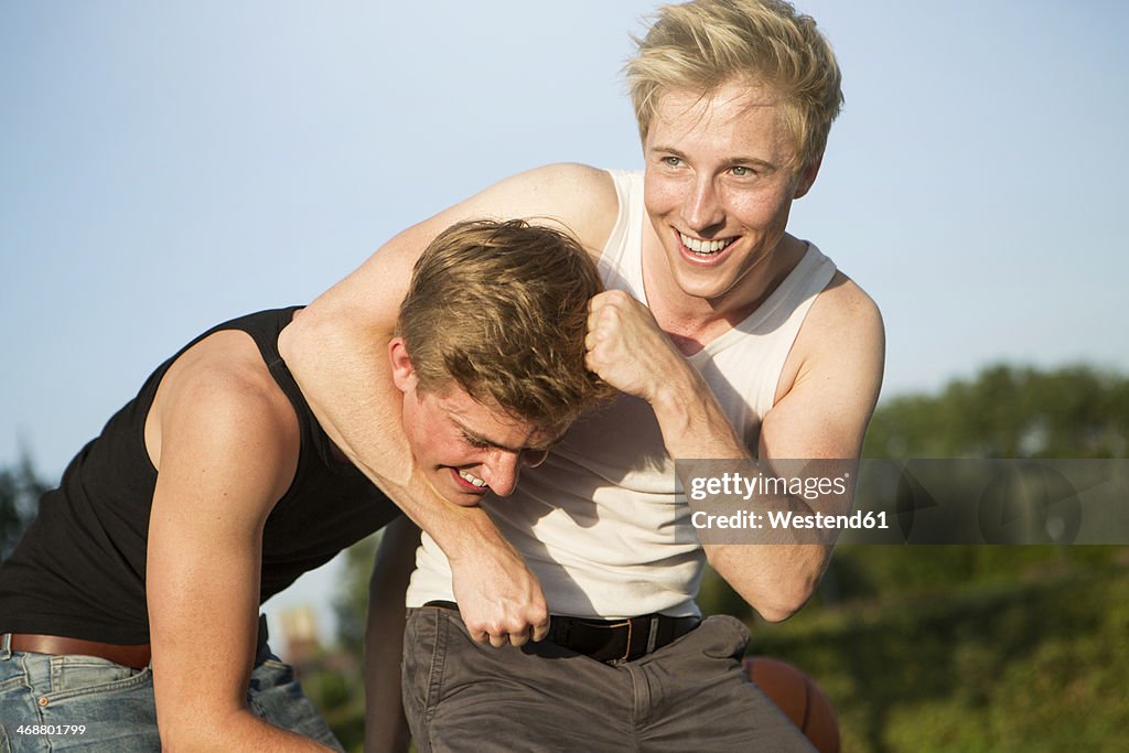 Germany, two friends having fun with a basketball