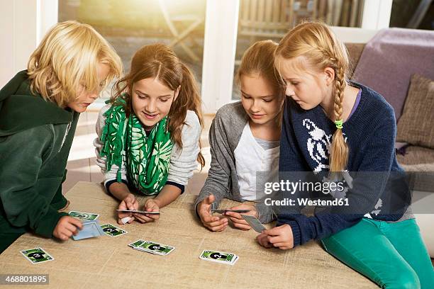 four children playing card game in living room - 4 people playing games stock pictures, royalty-free photos & images