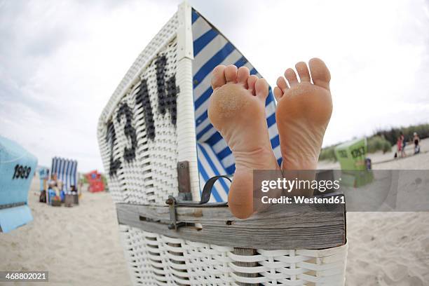 germany, lower saxony, east frisia, langeoog, feet on an armrest of a roofed wicker beach chair - beach shelter ストックフォトと画像