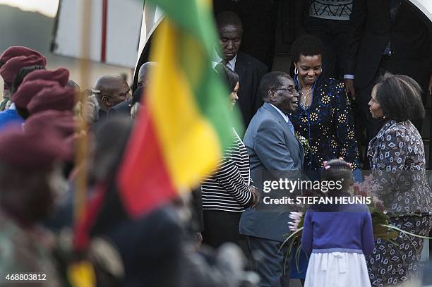 Zimbabwe's President Robert Mugabe and his wife Grace are greeted by South African Minister of International Relations and Cooperation Maite...