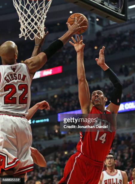 Taj Gibson of the Chicago Bulls blocks a shot by Gustavo Ayon of the Atlanta Hawks at the United Center on February 11, 2014 in Chicago, Illinois....