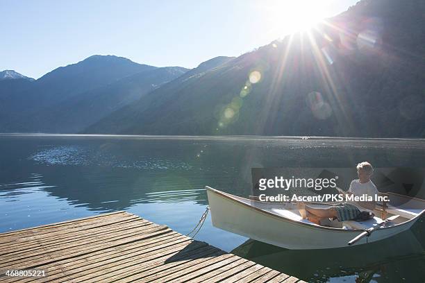 man relaxes in rowboat, uses digital tablet - moored stock pictures, royalty-free photos & images