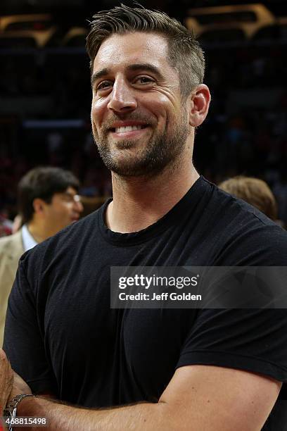 Quarterback Aaron Rodgers of the Green Bay Packers smiles as he stands on the court after the Wisconsin Badgers defeated the Arizona Wildcats 85-78...