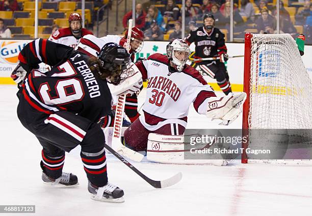 Cody Ferriero of the Northeastern University Huskies misses the net with a shot as Raphael Girard of the Harvard Crimson reaches-out during NCAA...